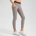 High-stretch grey yoga leggings with side pocket and Upgrade waistband. - S / Bottoms / Taupe