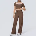Detail view of brown workout set featuring halter-neck crop top and wide-leg yoga pants - S / Top And Bottom / Chestnut Brown