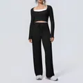 Front view of women's black yoga set with long sleeve crop top and wide-leg pants - S / Top And Bottom / Black