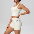 Detail view of high-waist cream yoga shorts featuring a functional side phone pocket. - S / Top And Bottom / Light Ivory