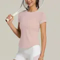 Primo piano di una t-shirt sportiva rosa ad asciugatura rapida da donna con racchetta da tennis - Taglia S / Top / Rosa Filato Morbido