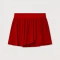 Detail view of a vibrant red pleated tennis skort with quick-dry fabric and asymmetric hem - S / Bottoms / Red