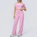 Close-up view of pink two-piece yoga set with halter neck top and wide-leg pants - Sakura Pink