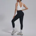 Detail of women's yoga set with white V-neck sports bra and black high waist leggings - White Top And Black Bottom