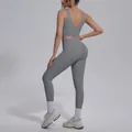 Back view of a grey V-neck sports bra and high-waisted yoga leggings set for women. - Titanium Gray