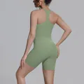 Achteraanzicht van een olijfgroene racerback sporttop en een korte strakke legging voor dames - Cedergroen