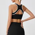 Back view of black sports bra with white trim and matching high-waist tennis skirt - S / Tops / Black