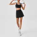 Model wearing black high-waisted tennis skirt and sports bra set with quick-dry white piping - S / Top And Bottom / Black