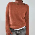 Close-up detail of soft burnt orange round neck knit sweater showing wool texture - Orange Red