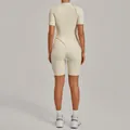 Back view of a sleek beige high-intensity yoga jumpsuit featuring a short sleeve design. - Beige