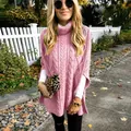 Detail van roze kabelgebreide coltrui poncho met stijlvolle zijsplitdetails - Roze