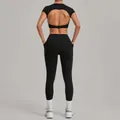Women's black yoga set with cutout back top and high-waisted leggings for fitness gym. - Black