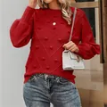 Close-up of red long-sleeve knitted sweater with textured pom-poms and elegant round neck - S / Tops / Red