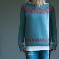 Close-up detail of women's teal knitted sweater featuring red geometric pattern accents. - Blue Base With Red Stripes