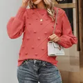 Model wearing coral knit sweater with pom-poms and lantern sleeves in detailed outdoor shot - Watermelon red