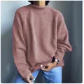 Dettaglio ravvicinato di un maglione oversize da donna in maglia rosa cipria - Rosa