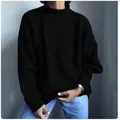 Detail of a black oversized knit sweater showing its relaxed fit and soft texture. - S / Tops / Black