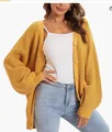 Detailed view of a chunky knit yellow cardigan with single-breasted buttons on a model. - Turmeric