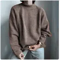 Dettaglio di un maglione marrone lavorato a maglia larga e casual da donna con collo alto. - Marrone scuro