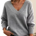Detail view of a loose grey V-neck knitted sweater with soft texture and ribbed collar - Light Gray