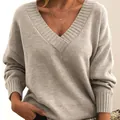 Detail view of the ribbed V-neckline on a grey oversized knit sweater for women. - Apricot
