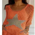 Close-up detail of a women's orange mesh knit top featuring a large silver glitter star - Orange Red