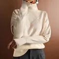 Close-up detail of a cream turtleneck knit sweater featuring a textured diamond pattern - S / Tops / Off White