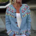 Detailed macro shot of women's knitted cardigan featuring vibrant floral patterns - S / Tops / Teal