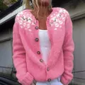 Close-up of pink knitted cardigan with floral shoulder embroidery and wooden buttons - S / Tops / Pink