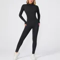 Detailed view of the black long-sleeved fleece-lined fitness jumpsuit on a model. - S / Top And Bottom / Black