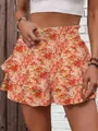 Detail view of stylish floral ruffle shorts with elastic high waist and tiered design - S / Bottoms / Orange Printed