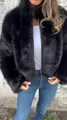 Detail view of women's black high-neck zip-up faux fur jacket for winter season. - S / Tops / Black