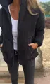 Dettaglio ravvicinato di una giacca in velluto a coste nera da donna con collo alto. - Nero