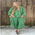 Detailweergave van een groene linnen-katoenen tweedelige set met lange mouwen op een model. - Groen