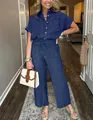 Donna indossa un set a due pezzi a righe blu con camicia e pantaloni in stile lifestyle - Blu navy