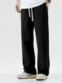 Close-up view of men's loose black wide-leg casual pants with a drawstring waist design. - S / Bottoms / Black
