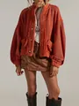 Detailed view of rust-orange oversized knit cardigan with fringe edge and metal buttons. - Orange Red