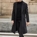 Detailed view of a mens long black wool blend overcoat in a classic British street style. - S / Tops / Black