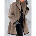 Détail d'un manteau d'automne en laine beige coupe large avec bordure noire contrastée. - Chameau