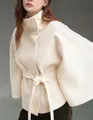 Detailed close-up of an elegant off-white woolen cape coat featuring a stand collar and belt - L / Tops / White