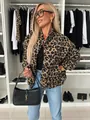 A stylish woman wearing a retro leopard print jacket and holding a chic black handbag - S / Tops / Leopard Print
