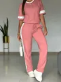 Vista dettagliata del completo casual rosa a due pezzi con strisce laterali bianche - Taglia S / Top E Pantaloni / Pesca