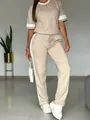 Dettaglio set casual beige due pezzi con strisce laterali bianche su maniche e pantaloni. - Taglia S / Top E Pantaloni / Kaki