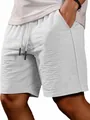 Close-up detail of the textured summer fabric and drawstring waist of gray casual shorts - White