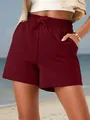 Detail of burgundy sports shorts featuring elastic drawstring waist and side pockets. - S / Bottoms / Burgundy