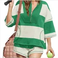 Close-up van model met groen gestreept oversized topje en short die een tennisbal vasthoudt - Wit + Groen