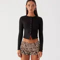 Front view detail of a slim-fit black ribbed cropped cardigan with leopard print ruffled shorts - Black