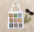 Primo piano del motivo colorato a uncinetto su una borsa tote bianca fatta a mano - Taglia unica / Bianco