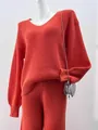 Close-up view of vibrant red V-neck knit sweater and matching pants two-piece set - S / Tops / Orange