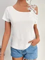 Close-up of white T-shirt featuring delicate floral lace applique on the shoulder - S / Tops / White